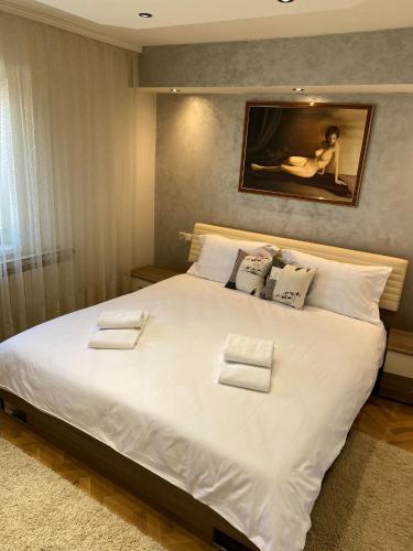 a bedroom with a large bed with white sheets and pillows at Astralis Factory Apartments- FLY in Zagreb