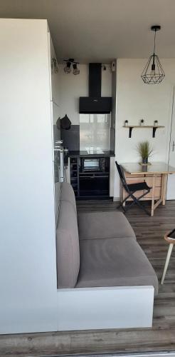 un salon avec un canapé et une table dans l'établissement Vue superbe sur l'océan, studio et stationnement, à Saint-Jean-de-Monts
