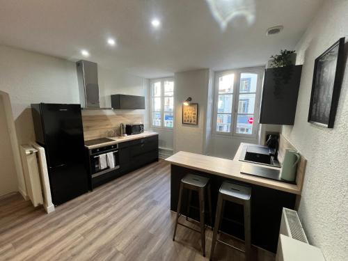 une cuisine avec des armoires noires et un comptoir dans l'établissement Cosy Center Av Des États-Unis, à Clermont-Ferrand