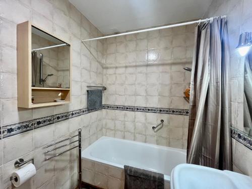 a bathroom with a tub and a sink at El Muro in Benalmádena