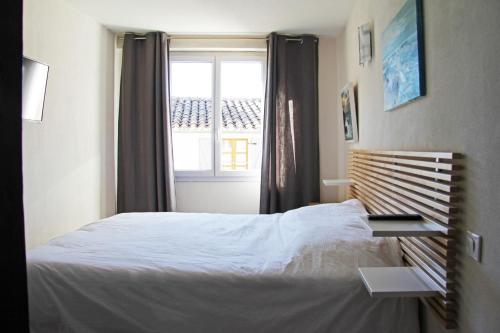 a bedroom with a white bed and a window at La Provençale in Valensole