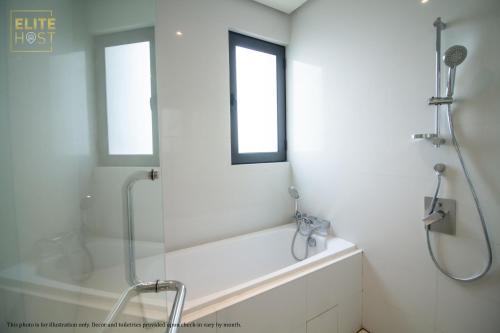 a white bathroom with a shower and a bath tub at PAVILION EMBASSY KLCC By ELITE HOST in Kuala Lumpur