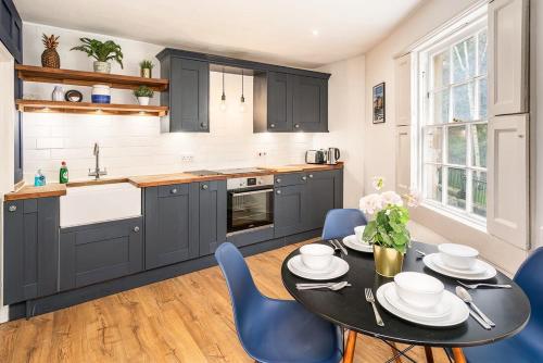 a kitchen with a black table and blue chairs at Beautiful Central 2 Bed Flat in Bath
