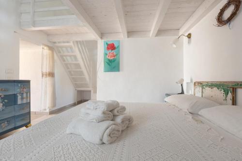 een slaapkamer met een bed met handdoeken erop bij Trullo Mandorlo by BarbarHouse in Carovigno