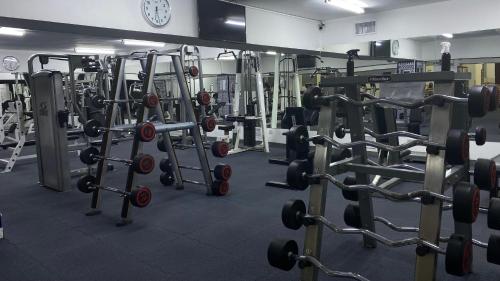 a gym with lots of weight machines and a clock at Toledo Amman Hotel in Amman