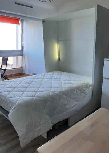 une chambre avec un grand lit dans une pièce dans l'établissement Vue superbe sur l'océan, studio et stationnement, à Saint-Jean-de-Monts