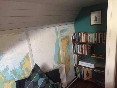 un mapa en la pared junto a un estante de libros en Sailing Barge Reminder, en Maldon