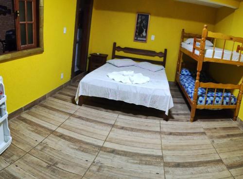 a bedroom with two bunk beds and yellow walls at Morada do Aventureiro in Angra dos Reis