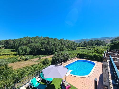 an overhead view of a swimming pool with an umbrella at Paço AL in Monção