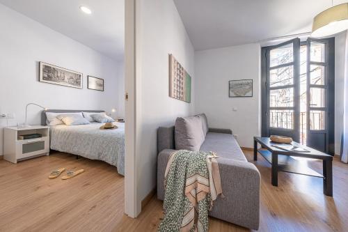 - une chambre avec un lit, une chaise et une table dans l'établissement Tarragona Apartments, à Tarragone