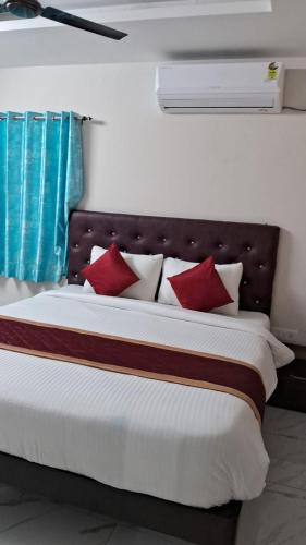 um quarto com uma cama grande e almofadas vermelhas em 7HILLSHOMESTAY em Tirupati