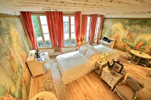 巴黎的住宿－A Gem at Notre Dame，卧室配有一张大床,墙上挂有绘画作品