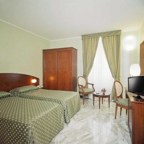 a bedroom with a bed and a tv in a room at Hotel Ulivi in Arenzano
