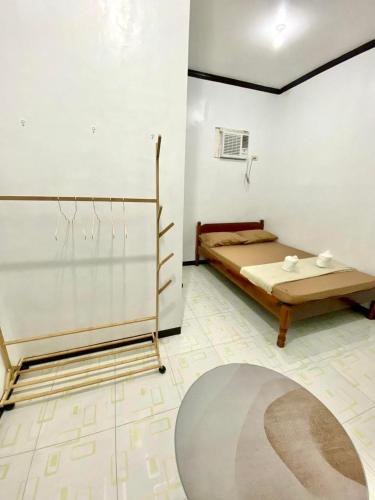a bedroom with a bed and a rug on the floor at Isla Casita Homestay Siargao in General Luna