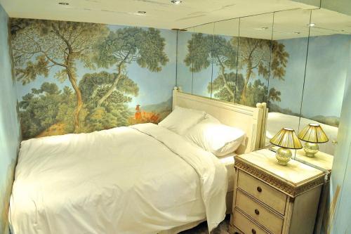 1 dormitorio con 1 cama blanca y una pintura en la pared en Tenderness at Notre Dame, DELACROIX, en París