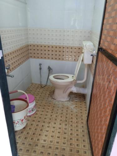 a bathroom with a pink toilet in a room at Advait Holiday Home in Nagaon