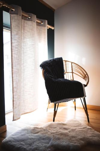 a black chair sitting in a room with a window at Maisonnette jardin jacuzzi au cœur de Chambles in Chambles