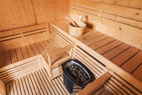 una vista interior de una sauna de madera con un cubo en T3c Gardens, en Lusaka