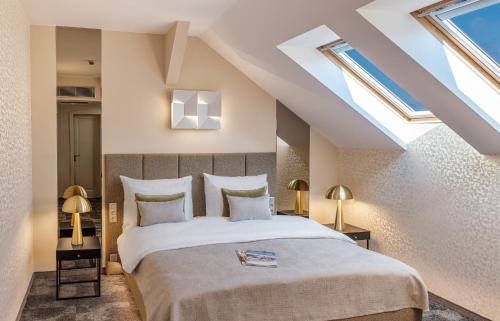 a bedroom with a large bed and skylights at Maestro by Adrez in Prague