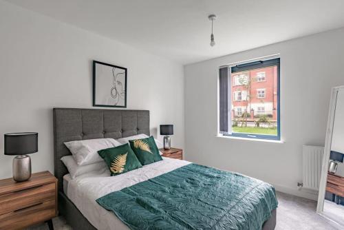 a bedroom with a large bed and a window at Modern 2 bed 2 bath apartment in the heart of York in York