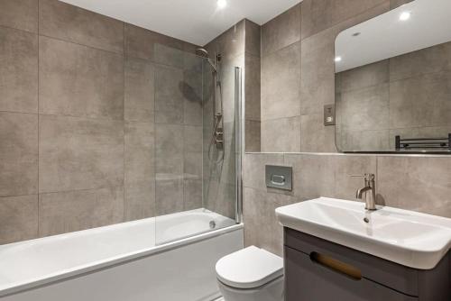 y baño con lavabo, aseo y bañera. en Modern 2 bed 2 bath apartment in the heart of York en York