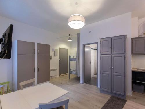 Il comprend un salon avec une table blanche et une cuisine. dans l'établissement Studio cosy rénové au centre de Cauterets, idéal pour 4, équipé et confortable - FR-1-401-283, à Cauterets