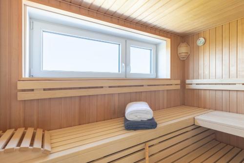 eine Sauna mit einem Fenster und einem Sitz darin in der Unterkunft Hannes Huis in Neukirchen