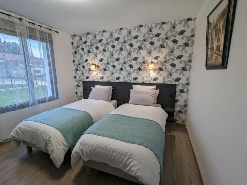 dwa łóżka w sypialni ze ścianą w obiekcie Gîte Épieds-en-Beauce, 3 pièces, 4 personnes - FR-1-590-424 w mieście Épieds-en-Beauce