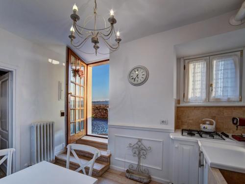 a kitchen with a clock on the wall and a window at La Casa Bianca with parking and view in Orvieto