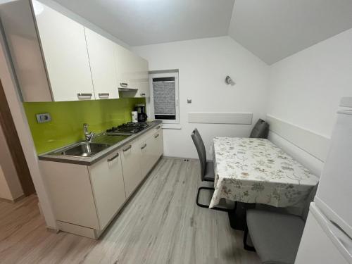 a small kitchen with a table and a sink at Apartmaji in Sobe Cuder in Soča