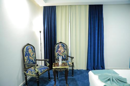 a room with two chairs and a table and a bed at فندق برهان الهدى Burhan Al-Huda ,Hotel in Makkah