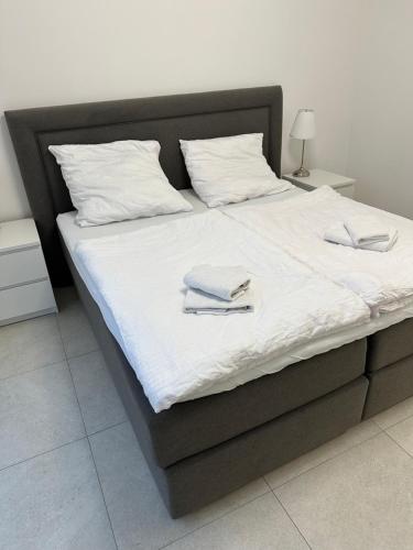 a bed with white sheets and two towels on it at 4 ZKB Neubauwohnung mit Stil in Bielefeld