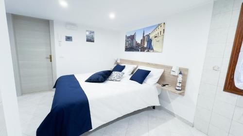 una camera da letto con un letto bianco con cuscini blu di Blue Eyes by Ca-Sa Check a Chioggia