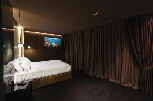 a bedroom with a bed with white sheets at Hotel Touring in Ferrara