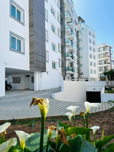 a view of a building with flowers in the foreground at North Residence Deniz Manzaralı Daire in Kérynia