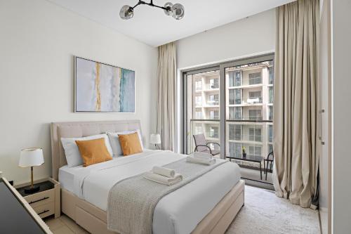 a white bedroom with a large bed and a window at New 2 Bedroom in Creek Reserve in Dubai