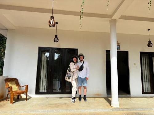 a man and a woman standing in front of a house at Fairline Gardens Hiriketiya in Dickwella