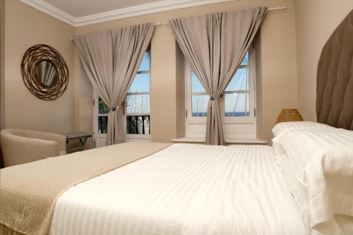 a bedroom with a large bed and two windows at Casa Natalie La Marina in Puerto Calero