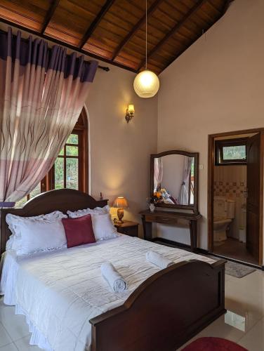 a bedroom with a large bed and a mirror at Ella Heaven Inn in Kumbalwela