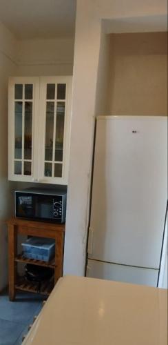 La cuisine est équipée d'un réfrigérateur blanc et d'un four micro-ondes. dans l'établissement Appartement lumineux, à Montreuil