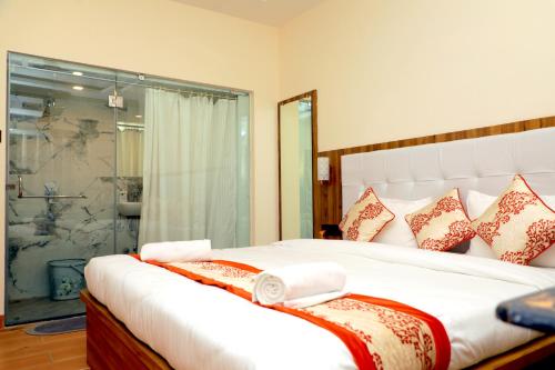 una camera da letto con un grande letto bianco con cuscini di De Classico Hotel a Varanasi