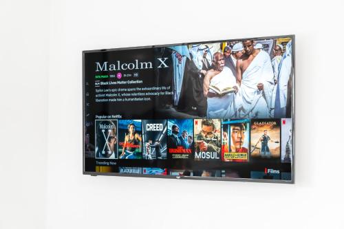 a poster for malcolm x on a wall at 2 Bedroom Deluxe Apartment - Secure Parking - Wifi - Netflix - Top Rated - 27C in Sleightholme