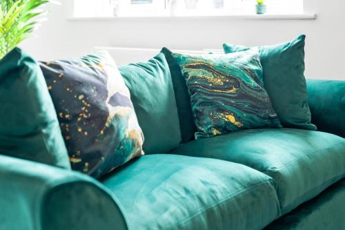 a blue couch with pillows on it in a living room at 2 Bedroom Deluxe Apartment - Secure Parking - Wifi - Netflix - Top Rated - 27C in Sleightholme
