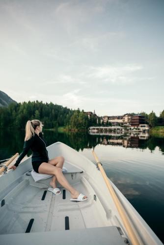 a woman sitting on a boat in the water at Hotel Hochschober in Turracher Hohe
