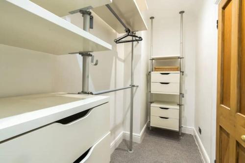 a kitchen with white cabinets and a sink at 3 x Bedroom Riverside Flat with Beach in London