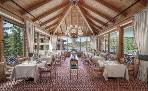 un comedor con mesas, sillas y ventanas en Hotel Hochschober, en Ebene Reichenau