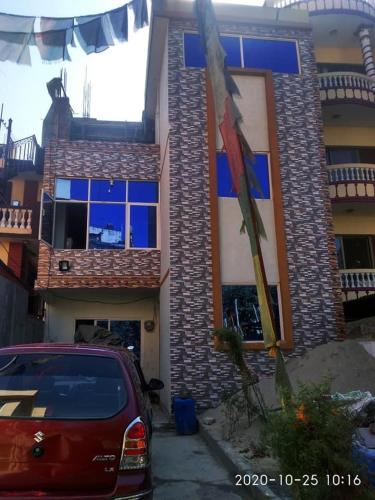 a red car parked in front of a house at Sanumaya Guest house in Kathmandu