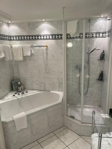 a white bathroom with a tub and a shower at Walters Hof Kampen in Kampen