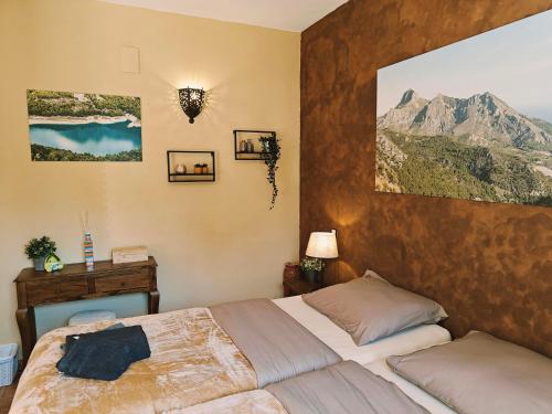 a bedroom with a bed and a painting on the wall at Finca Oliva in Bolulla