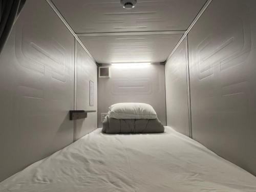 um pequeno quarto com uma cama no meio em Business Hotel Legato em Tóquio